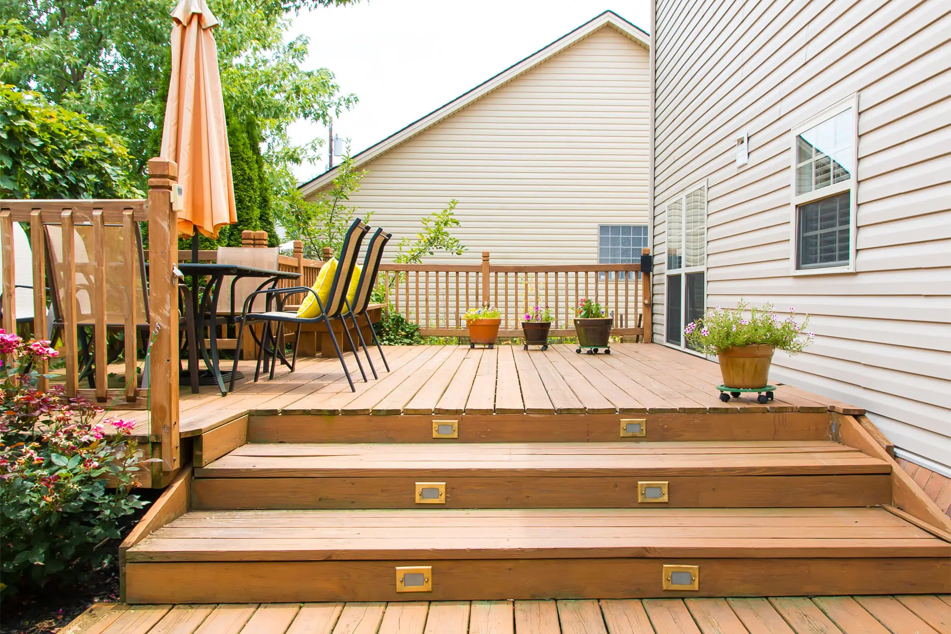 A wooden deck featuring steps leading down, showcasing natural wood grain and a spacious outdoor area.